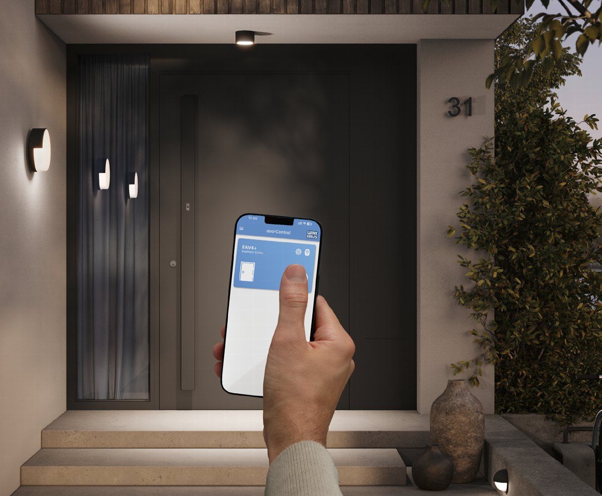 Mano con un móvil abriendo una puerta de entrada con una app