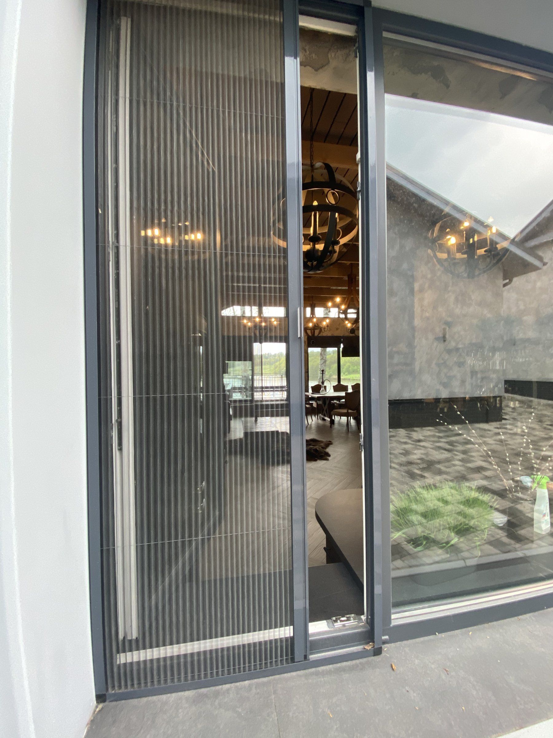 Pleated fly screen drawn across a large sliding terrace door