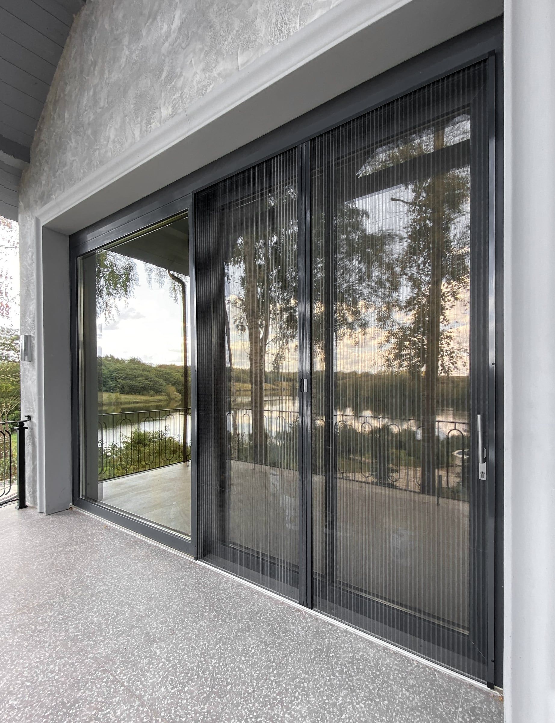 Wide sliding terrace door fully covered by plissé fly screens